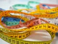 Många färgglada måttband ligger huller om buller. Ett gult måttband med siffror som 67, 68, 69, 70, 71, 72, 73, 74 ger ny rad.