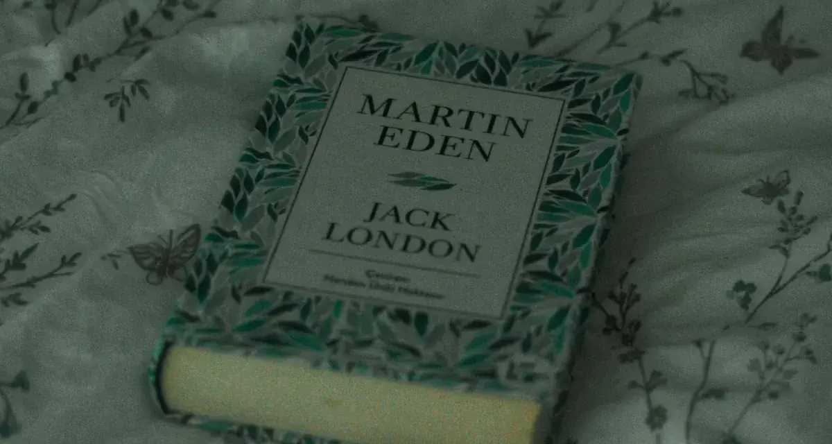 En bok med titeln "Martin Eden" av Jack London ligger på ett mönstrat tyg. En perfekt bok för att förlora sig i en novell.