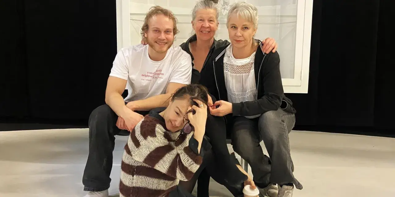 Sara Stridsberg familj, en glad skådespelarensemble poserar tillsammans på scenen.