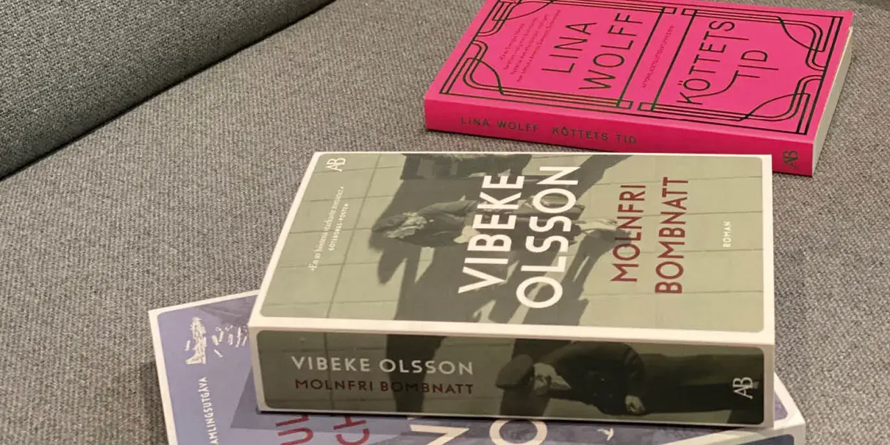 Tre böcker ligger på en soffa. En av dem heter "Molnfri bombnatt" av Vibeke Olsson.