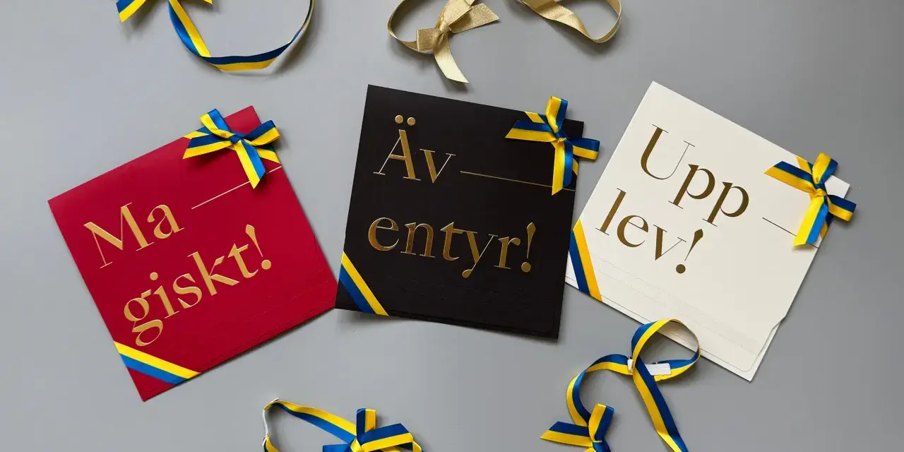 Grattis! Kort med texten "Magiskt!", "Äventyr!" och "Upplev!" i guldfärgad skrivstil, dekorerade med blågula band.