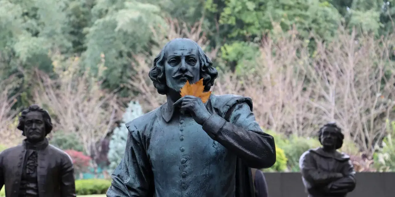 Staty av Shakespeare med ett löv framför munnen, som ett sonett exempel. Bakom syns andra statyer och träd.