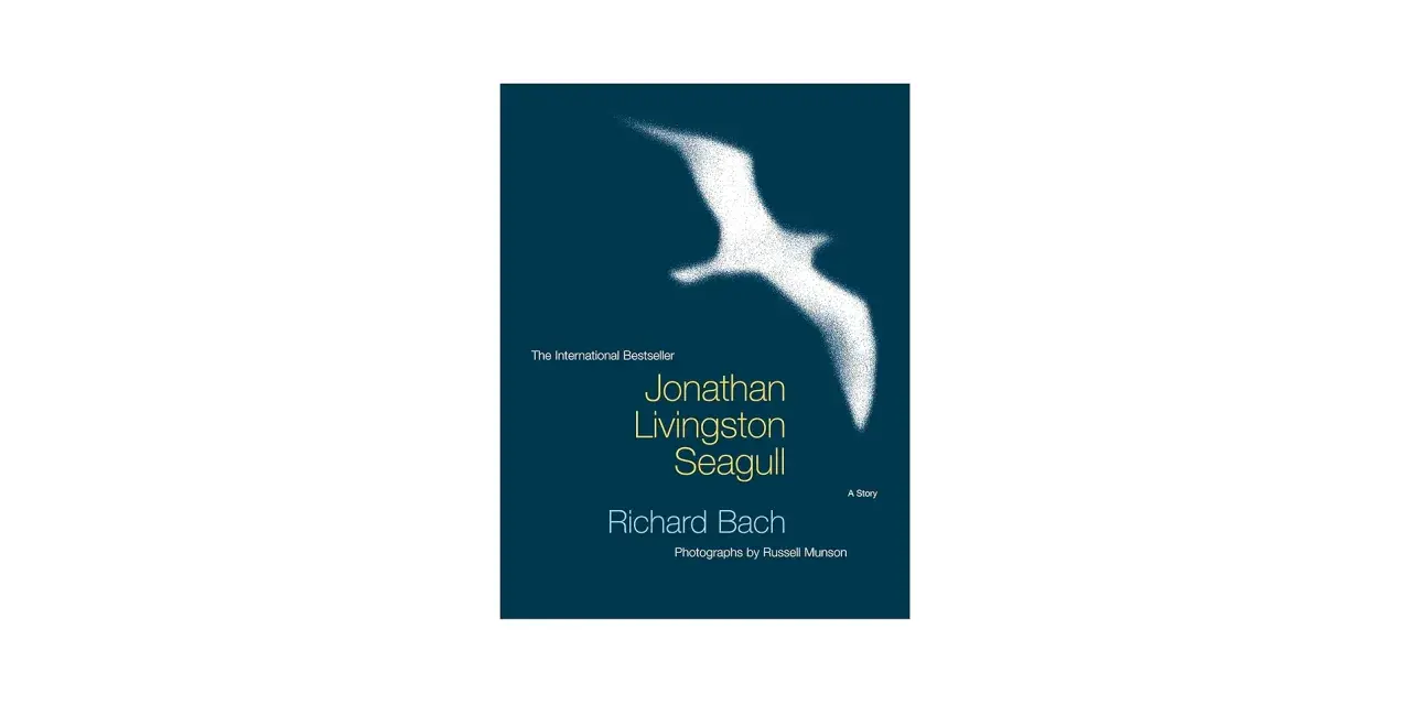 Bokomslag för "Jonathan Livingston Seagull" av Richard Bach. En vit, sprödad måsen flyger över en mörkblå bakgrund.