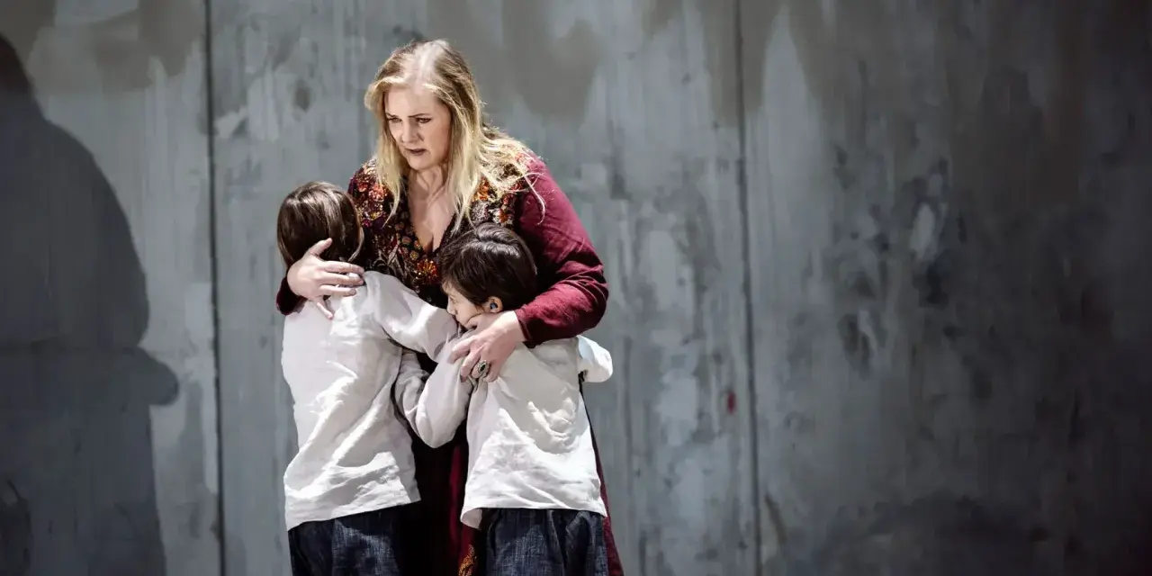 Medea, med en blick av sorg, kramar sina barn. En scen ur en pjäs om Jason och Medea.