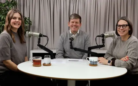 Tre personer sitter vid ett runt bord med mikrofoner framför sig. De verkar spela in en podcast, kanske om arv, synonymt med det som lämnas kvar.