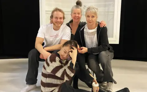 Sara Stridsberg familj, en glad skådespelarensemble poserar tillsammans på scenen.