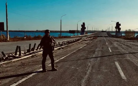 Soldat på en förstörd bro över en flod. Scenen är en absurd synonym för krigets fasor.