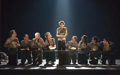Barn i fattiga kläder med tomma tallrikar, en scen som visar vad som handlar oliver twist om: kampen för överlevnad och mat.