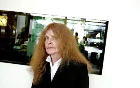 Kristina Lugn, känd för sina dikter, med sitt karaktäristiska röda hår och blick.