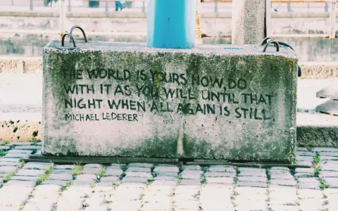 En betongklump med texten "The world is yours now, do with it as you will until that night when all again is still. Michael Lederer." En dikt om ensamhet som känns tidlös.