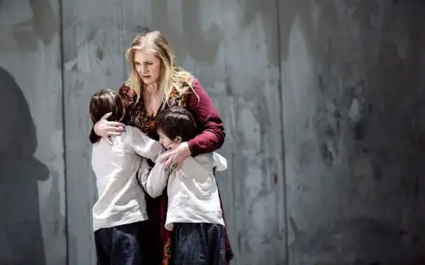 Medea, med en blick av sorg, kramar sina barn. En scen ur en pjäs om Jason och Medea.