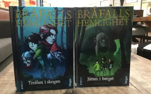 Två böcker, "Trollen i skogen" och "Jätten i berget", med fantasifulla illustrationer. Ett allegori exempel på äventyr.