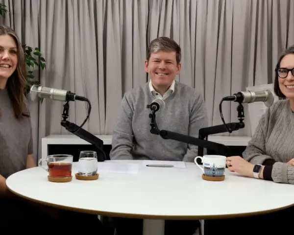 Tre personer sitter vid ett runt bord med mikrofoner framför sig. De verkar spela in en podcast, kanske om arv, synonymt med det som lämnas kvar.