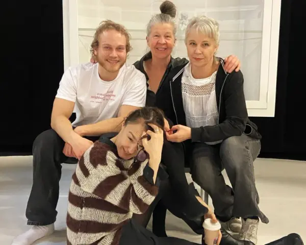 Sara Stridsberg familj, en glad skådespelarensemble poserar tillsammans på scenen.