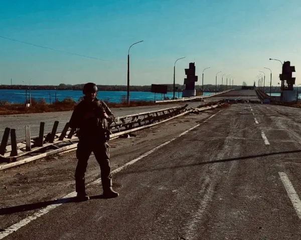 Soldat på en förstörd bro över en flod. Scenen är en absurd synonym för krigets fasor.