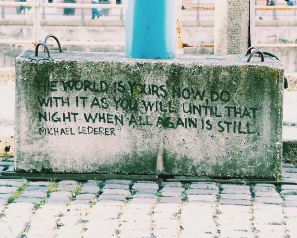 En betongklump med texten "The world is yours now, do with it as you will until that night when all again is still. Michael Lederer." En dikt om ensamhet som känns tidlös.