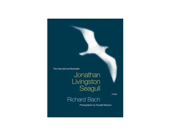 Bokomslag för "Jonathan Livingston Seagull" av Richard Bach. En vit, sprödad måsen flyger över en mörkblå bakgrund.