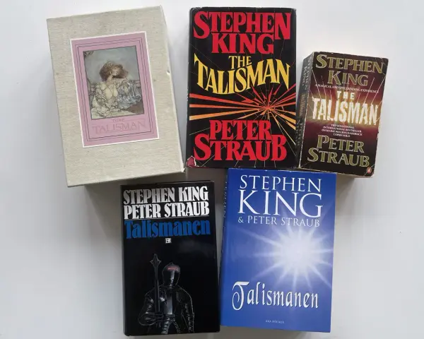 Samling av böcker av Stephen King och Peter Straub, inklusive olika utgåvor av "The Talisman" och "Talismanen". En hyllning till Stephen King att skriva.