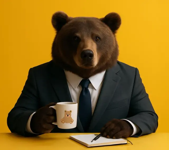 En björn i kostym sitter vid ett gult bord med en mugg och en anteckningsbok. Han funderar på hur lång ska en inledning vara.
