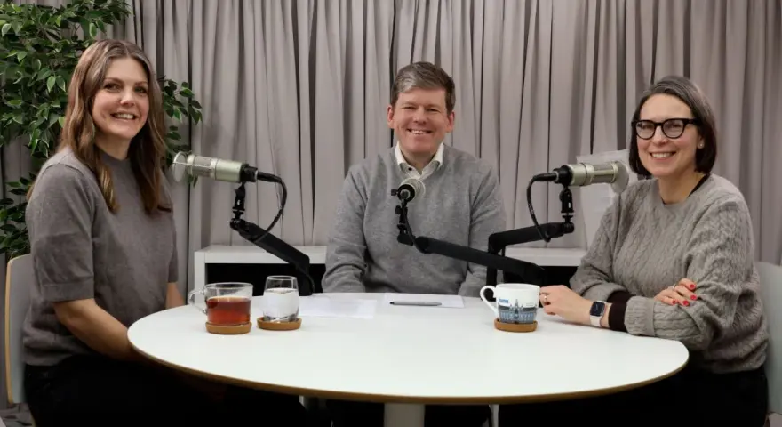 Tre personer sitter vid ett runt bord med mikrofoner framför sig. De verkar spela in en podcast, kanske om arv, synonymt med det som lämnas kvar.
