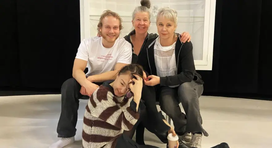 Sara Stridsberg familj, en glad skådespelarensemble poserar tillsammans på scenen.