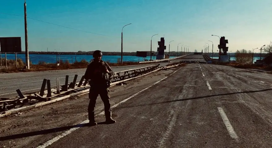 Soldat på en förstörd bro över en flod. Scenen är en absurd synonym för krigets fasor.