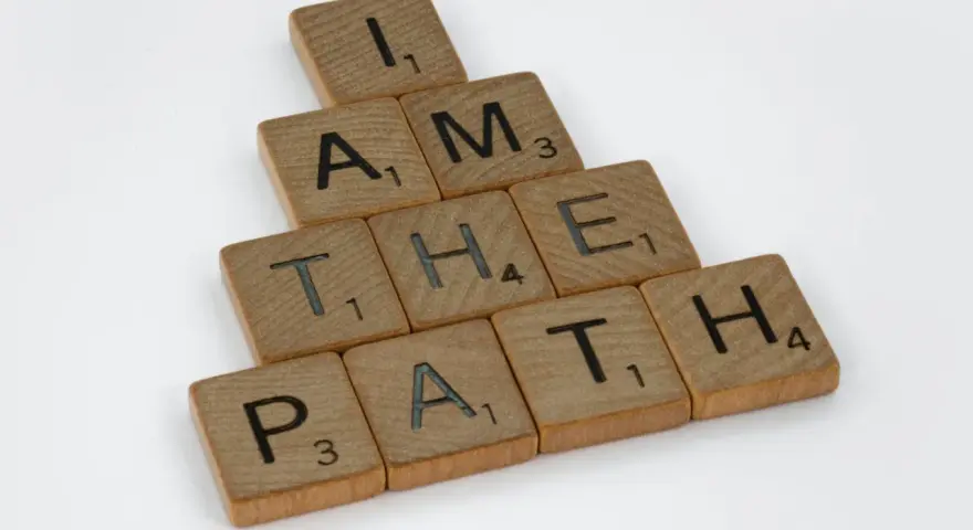 Bokstäver på träbrickor bildar frasen "I AM THE PATH" i en bunden form.