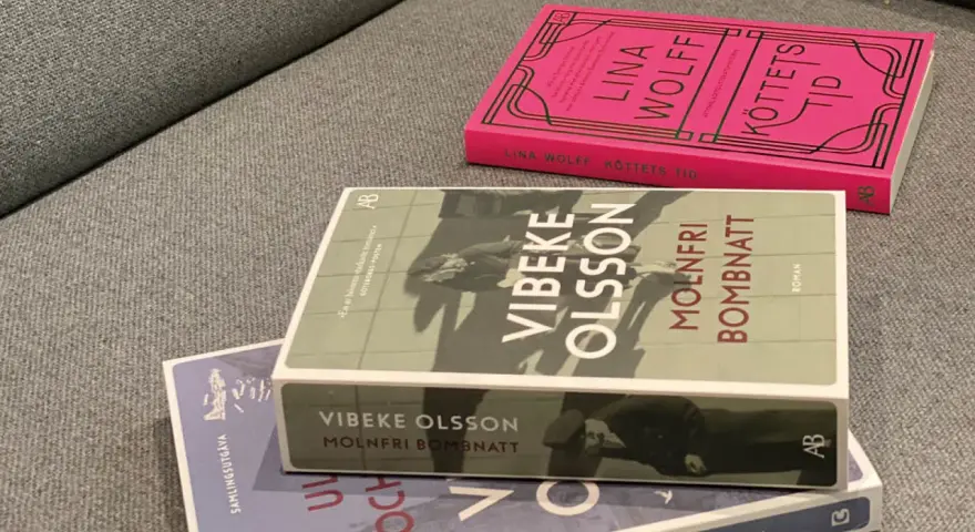 Tre böcker ligger på en soffa. En av dem heter "Molnfri bombnatt" av Vibeke Olsson.