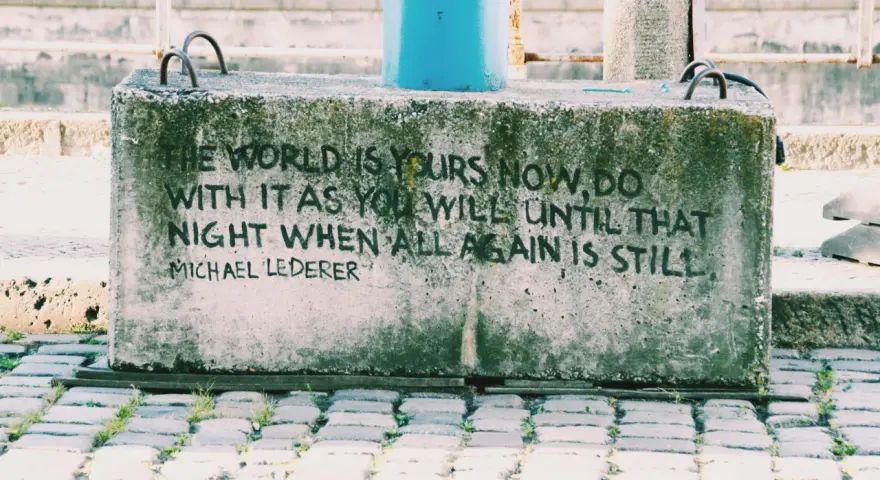 En betongklump med texten "The world is yours now, do with it as you will until that night when all again is still. Michael Lederer." En dikt om ensamhet som känns tidlös.