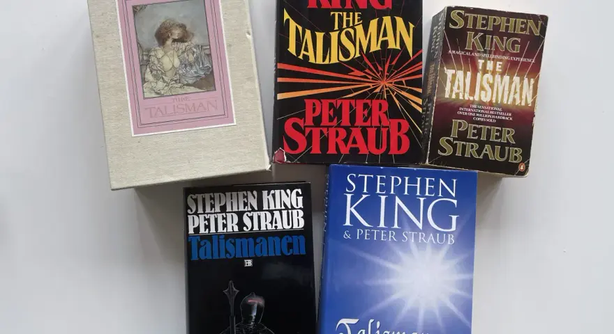 Samling av böcker av Stephen King och Peter Straub, inklusive olika utgåvor av "The Talisman" och "Talismanen". En hyllning till Stephen King att skriva.