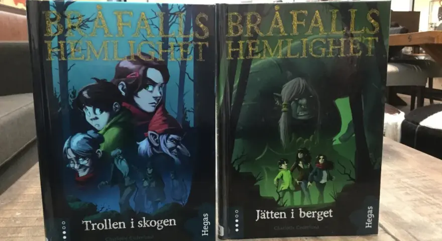 Två böcker, "Trollen i skogen" och "Jätten i berget", med fantasifulla illustrationer. Ett allegori exempel på äventyr.