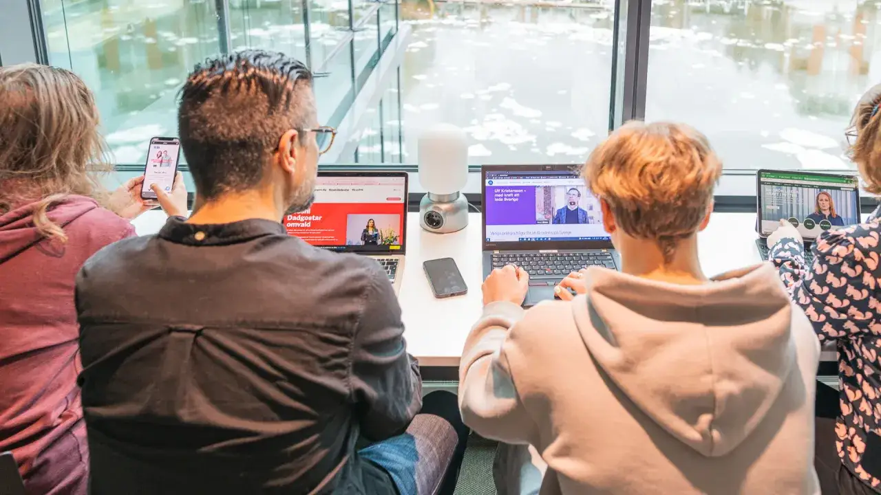 Fyra personer vid datorer och en mobil. En sk&auml;rm visar en politisk debatt, en annan en intervju med Ulf Kristersson. En diskussion om politiska fr&aring;gor, en polemik synonym.