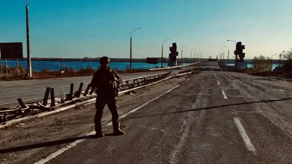 Soldat på en förstörd bro över en flod. Scenen är en absurd synonym för krigets fasor.
