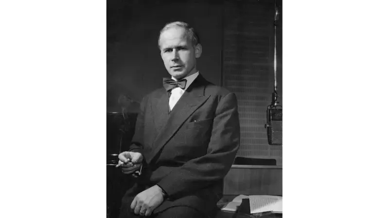 Olof Lagercrantz, klädd i kostym och fluga, sitter med en cigarett i handen framför en mikrofon.
